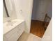Powder room with single sink vanity and white cabinetry plus a view into an upstairs hallway at 9105 Capsdale Ct, Huntersville, NC 28078