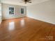 This is an empty primary bedroom with hardwood floors, neutral colored walls and two windows at 9105 Capsdale Ct, Huntersville, NC 28078
