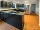 Well-lit kitchen featuring a large island cooktop, stainless steel refrigerator, and sleek dark cabinetry at 9105 Capsdale Ct, Huntersville, NC 28078