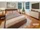 Comfortable bedroom with natural light, wood floors, and stylish decor, creating a relaxing retreat at 9105 Capsdale Ct, Huntersville, NC 28078