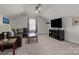 Cozy bonus room features a comfortable sofa, flat screen television and ceiling fan at 111 Old Field Rd, Statesville, NC 28677