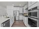 Well-lit kitchen with white cabinets, stainless steel appliances, and wood flooring at 111 Old Field Rd, Statesville, NC 28677