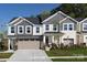 Charming townhome showcases a stylish facade with gray shingles, a 2-car garage, and manicured front lawn at 12233 Gambrell Dr, Charlotte, NC 28278