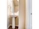 Charming powder room with pedestal sink, stylish mirror, and wood-look flooring at 12237 Gambrell Dr, Charlotte, NC 28278