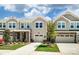 Inviting townhouse exterior featuring a well-manicured lawn, stone accents, and a two-car garage at 12237 Gambrell Dr, Charlotte, NC 28278