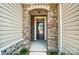 Close-up of a front doorway framed with stone work and beige siding at 12237 Gambrell Dr, Charlotte, NC 28278