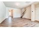 Open-concept living room with wood floors, and views of the entrance and staircase at 12237 Gambrell Dr, Charlotte, NC 28278