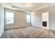 Spacious bedroom with tray ceiling, carpet floors, and ensuite bathroom at 12237 Gambrell Dr, Charlotte, NC 28278