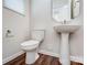 A bathroom with a white toilet, pedestal sink, hexagon mirror and wood-look floors at 12241 Gambrell Dr, Charlotte, NC 28278