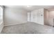 An empty bedroom with neutral carpet, closet, and a white door at 12241 Gambrell Dr, Charlotte, NC 28278