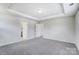 Bedroom featuring neutral carpet, tray ceiling, closet, and a white door at 12241 Gambrell Dr, Charlotte, NC 28278