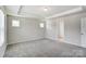 Bedroom featuring neutral carpet, tray ceiling, white door, and two windows at 12241 Gambrell Dr, Charlotte, NC 28278