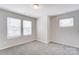 This bedroom features neutral carpet and three windows at 12241 Gambrell Dr, Charlotte, NC 28278