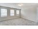 Bright bedroom featuring neutral carpet, three windows with horizontal blinds, and a ceiling light at 12241 Gambrell Dr, Charlotte, NC 28278