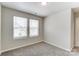 Bright bedroom features neutral carpet, two windows with blinds, and fresh paint at 12241 Gambrell Dr, Charlotte, NC 28278