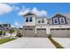 Charming townhome showcasing a three-car garage and tasteful exterior finishes including stone details at 12241 Gambrell Dr, Charlotte, NC 28278