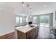 Open-concept kitchen features a large island with sink and pendant lights, seamlessly connected to the living area at 12241 Gambrell Dr, Charlotte, NC 28278