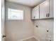 Functional laundry area with cabinets above washer/dryer hookups and a window at 12241 Gambrell Dr, Charlotte, NC 28278