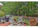 Outdoor patio with a grill, table, and chairs surrounded by beautiful greenery at 12606 Bradford Hill Ln, Huntersville, NC 28078