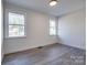 A bright bedroom featuring new vinyl floors and two large windows providing plenty of natural light at 1522 Wickham Ln, Charlotte, NC 28208