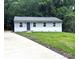 Charming single-story home with gray siding, a well-manicured lawn, and a newly paved concrete driveway at 1522 Wickham Ln, Charlotte, NC 28208