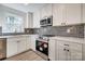 The renovated kitchen boasts stainless steel appliances, white cabinets, and modern backsplash at 1522 Wickham Ln, Charlotte, NC 28208