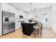 Modern kitchen featuring white cabinets, stainless steel appliances, and a black kitchen island at 3812 Odom Way, Charlotte, NC 28216