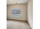 Simple bedroom features neutral carpet and a window offering natural light at 508 Stone River Pkwy, Mount Holly, NC 28120