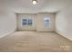 Large bonus room with neutral carpet and two windows offering natural light at 508 Stone River Pkwy, Mount Holly, NC 28120