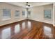 Bright living room with hardwood floors, ceiling fan, and multiple windows providing natural light at 508 Stone River Pkwy, Mount Holly, NC 28120