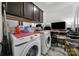 Laundry room with front load washer/dryer, dark cabinets above, and a small television at 5239 Admirals Lndg, Lancaster, SC 29720