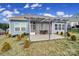 Backyard patio with a pergola, tile floor, two stools, and small decorative trees at 5239 Admirals Lndg, Lancaster, SC 29720