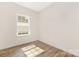 Bright bedroom with wood-look flooring and a large window providing natural light at 8465 Old Plank Rd, Charlotte, NC 28216