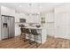 Modern kitchen featuring white cabinets, stainless steel appliances, an island with bar stools, and wood floors at 8465 Old Plank Rd, Charlotte, NC 28216