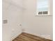 Functional laundry room with hookups, shelving, and a window at 8465 Old Plank Rd, Charlotte, NC 28216