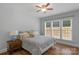 Cozy bedroom featuring a large window, hardwood floors, and a ceiling fan at 9900 Silverling Dr, Waxhaw, NC 28173
