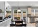Dining room with a view of the connected living area, with large windows, a table, and chairs at 9900 Silverling Dr, Waxhaw, NC 28173