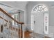 Bright foyer featuring hardwood floors, a staircase, and a decorative arched window above the front door at 9900 Silverling Dr, Waxhaw, NC 28173