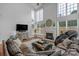 Bright living room with a fireplace, a comfortable leather sofa, and large windows providing ample light at 9900 Silverling Dr, Waxhaw, NC 28173