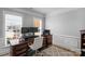 Office space with a traditional wooden desk, comfortable chair, and natural light from two windows at 9900 Silverling Dr, Waxhaw, NC 28173