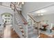 Elegant staircase leading to the second floor, showcasing hardwood floors and access to the dining room at 9900 Silverling Dr, Waxhaw, NC 28173
