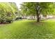 Large backyard with green grass, trees, landscaping, and a fenced in yard at 10213 Conistan Pl, Cornelius, NC 28031