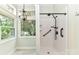 Bright bathroom featuring a walk-in shower with white tile, and a large window overlooking greenery at 10213 Conistan Pl, Cornelius, NC 28031