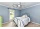 The bedroom is painted blue and features carpet, a window and a vintage bed frame at 10213 Conistan Pl, Cornelius, NC 28031