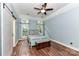 Cozy bedroom with hardwood floors, a ceiling fan, and a sliding barn door at 10213 Conistan Pl, Cornelius, NC 28031