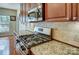 Close-up of a modern gas stovetop with granite counters and tile backsplash at 1114 Oak Alley Dr, Indian Trail, NC 28079