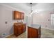 This eat-in kitchen boasts tile floors, warm wood cabinets, and a sliding door with a view of the outdoor deck at 11210 Northwoods Forest Dr, Charlotte, NC 28214