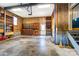 Spacious garage with wood paneled walls, built-in shelving, concrete flooring and garage door at 1207 Chadbourne Ave, Concord, NC 28027