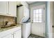 Efficient laundry area features a stackable washer/dryer and a convenient sink near an exterior door at 1207 Chadbourne Ave, Concord, NC 28027