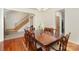 Formal dining room featuring a large table, hardwood floors, and an open view into the home's entryway and staircase at 125 Cherokee Dr, Mooresville, NC 28117